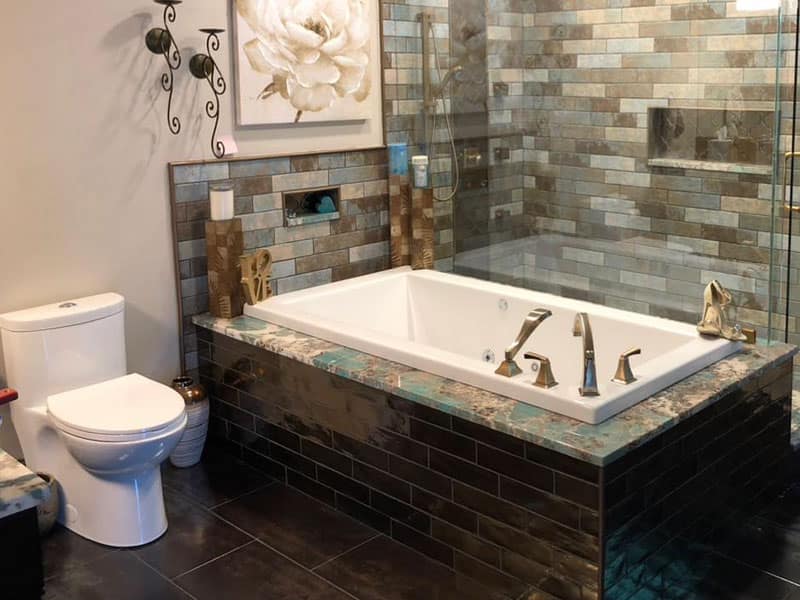 Luxury bathroom remodel featuring a tiled walk-in shower, soaking tub with bronze fixtures, and modern tilework