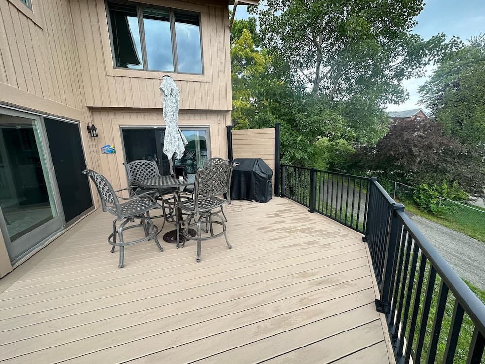 Modern elevated deck with composite decking and black railing for outdoor living spaces.